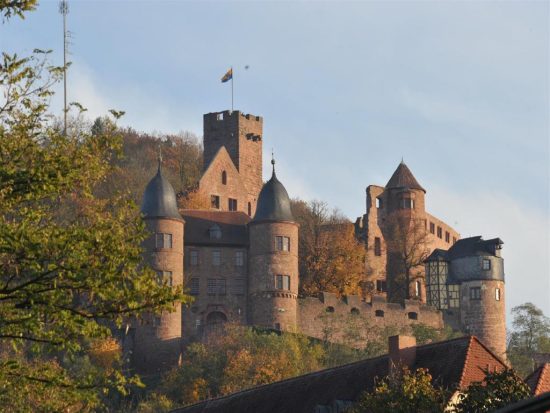 Außenansicht Schloss Taubertalde mit vielen gemauerten Türmen und einer Burgmauer